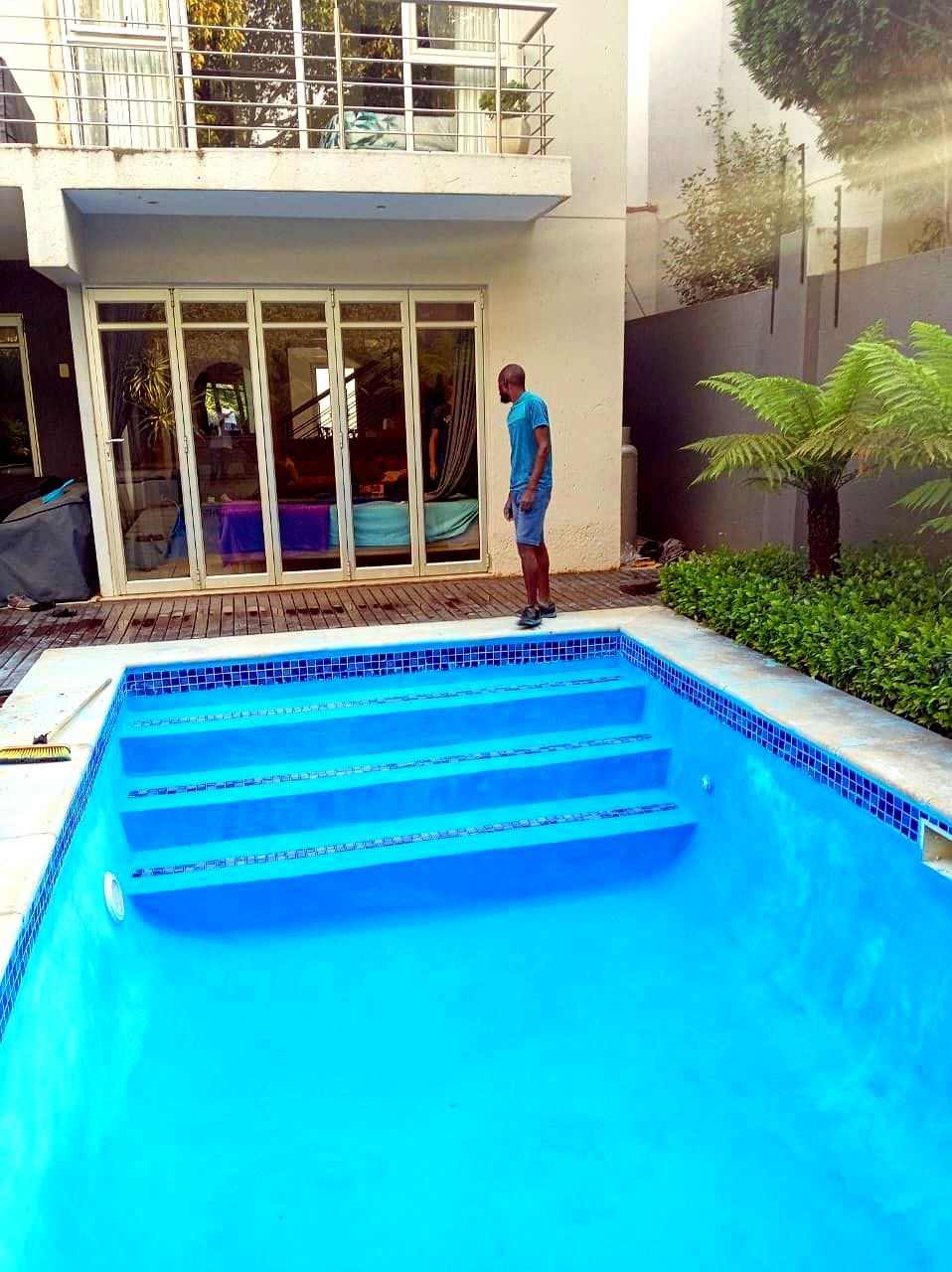 Resurfaced pool with wide steps at modern home